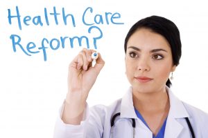 Stock image of female doctor writing on whiteboard: Health care reform?... Image over white background